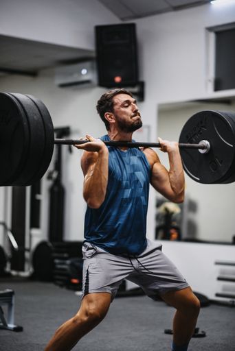 A vertical shot of an athletic man doing the exercise at the gym
