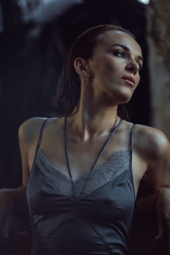 A sexy Caucasian woman wearing a lingerie top through the mirror