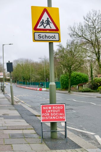 A vertical shot of a warning sign about School children on the side of the street