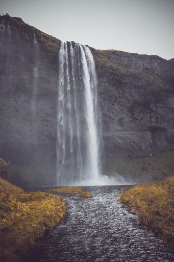 A vertical shot of the Seljalandsfoss waterfall on a gloomy day in Iceland