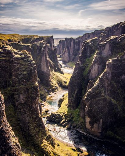 A vertical shot of the Fjadrargljufur Canyon under the sunlight in Iceland