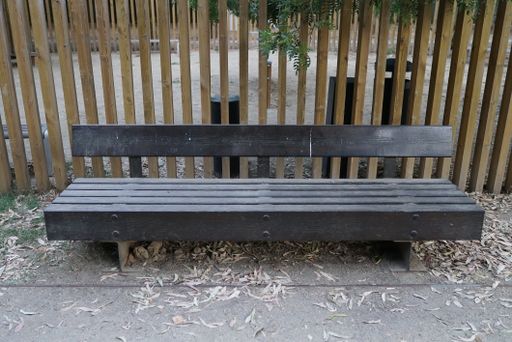 A closeup shot of a metal bench in a park
