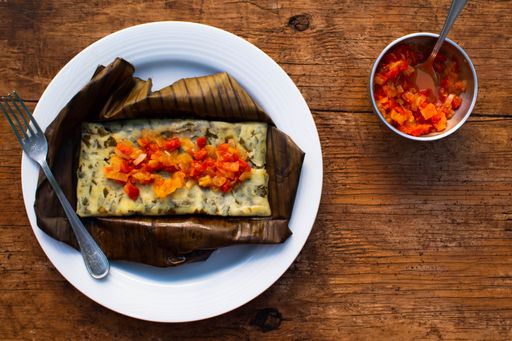 overhead mexican food with sauce from the riviera maya on a white plate served on a wooden table