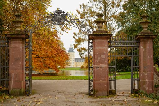 A horizontal photo of Karlsruhe Palace's gate in Germany, surrounded by vibrant autumn colors.
