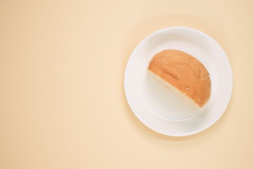 A top view shot of half bread on a coral background