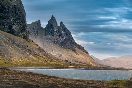 Scenic view of Vestrahorn mountain in Iceland with dramatic clouds and rugged landscape by the sea.