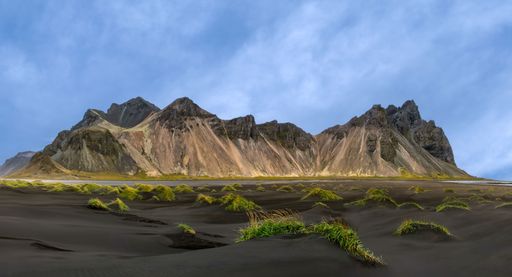 Majestic Vestrahorn mountain with black sand dunes under a clear blue sky in Iceland.