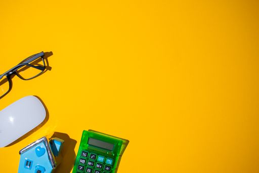 A top view of a neon orange surface with small objects on it at the bottom left corner