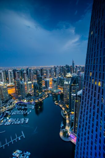 A vertical high angle shot of the beautiful Dubai marina with buildings lights shining under the sky
