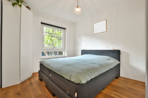 A modern bedroom with a gray bed and white closet