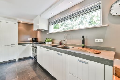 A kitchen with the furniture in it and the bright light coming from the window