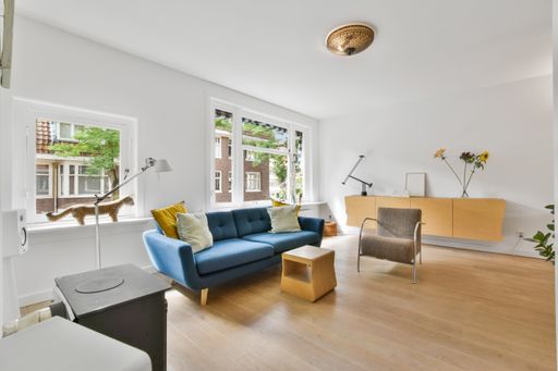 A modern living room interior with a blue sofa and colorful decor