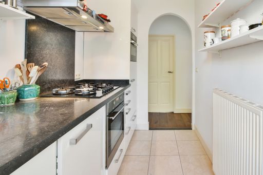 A kitchen with the furniture in it and the bright light coming from the window