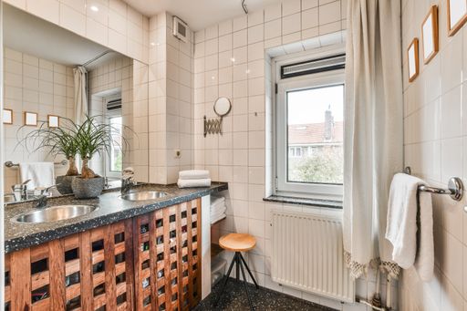A bathroom interior with two sinks, a large mirror, and wooden details