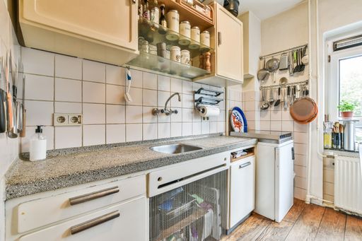 A kitchen with the furniture in it and the bright light coming from the window