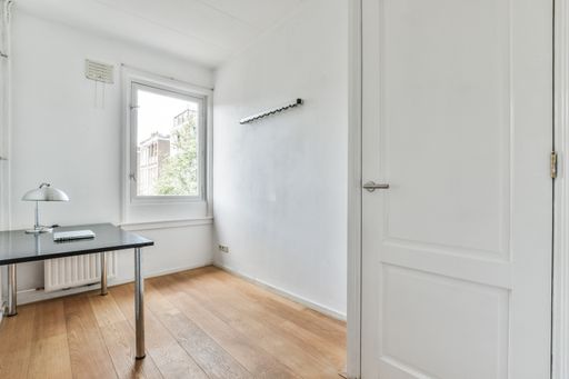 A modern room with furniture and the bright light coming from the window
