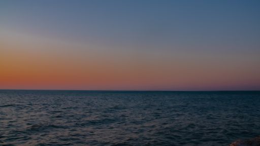 A long exposure shot of a calm sea during sunset