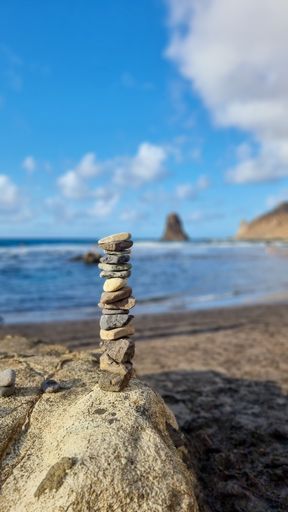 A vertical shot of rocks stacked on top of each other on a warm summer day with a blurry background