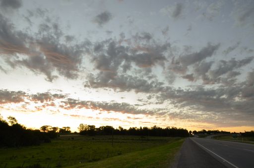 sky with clouds in an orange sunset seen from the road in the Uruguayan countryside