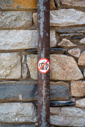A vertical shot of a metal column and a "no crown" sign on it