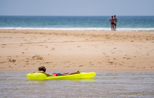 A young boy relaxing laying on the yellow air inflatable mattress on the sea