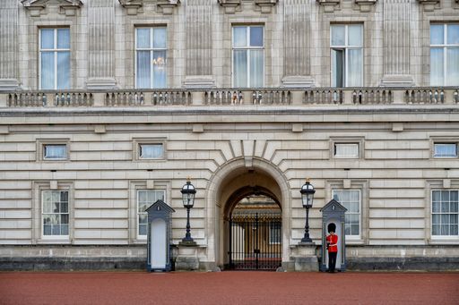 Queen's guards in red uniforms perform at Buckingham Palace, London