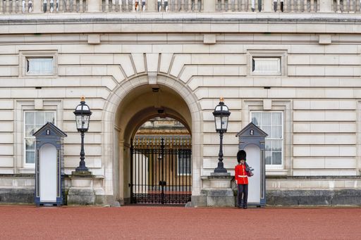 Queen's guards in red uniforms during the Changing of the Guard at Buckingham Palace.