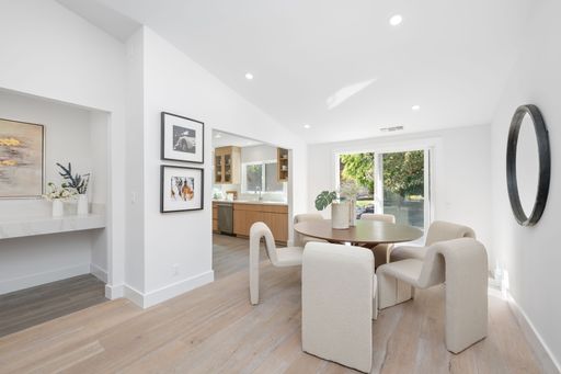 Modern dining room with stylish furniture, large windows, and minimalist decor in a bright interior setting.