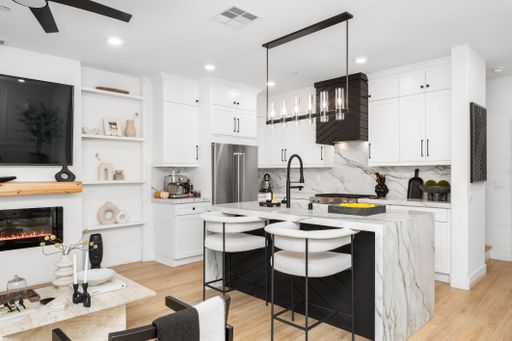Modern kitchen interior with marble island, sleek appliances, and stylish decor in a bright, contemporary home setting.
