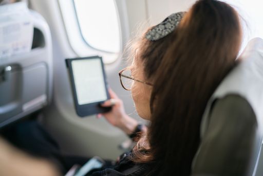 Woman reading electronic book during flight on airplane