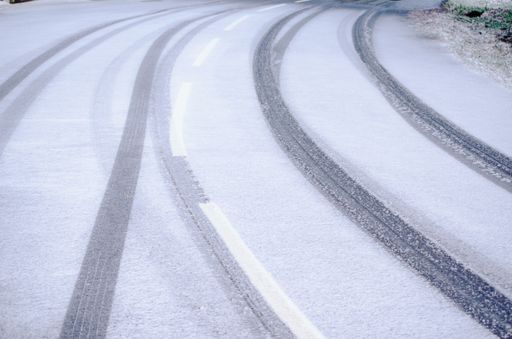 tire mark of a car on a snow covered winter road, transport in winter background concept