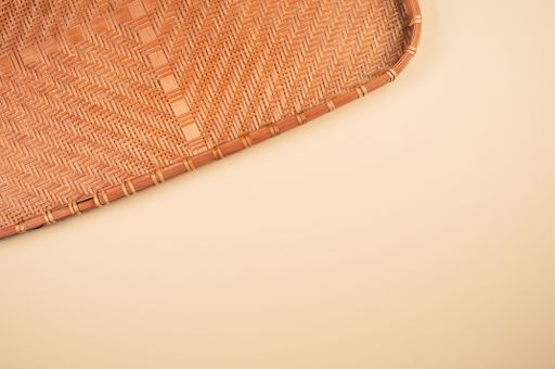 A top view of bamboo wicker tray isolated on brown background