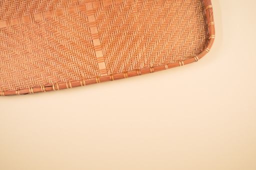 A high angle shot of a woven fabric on an orange surface