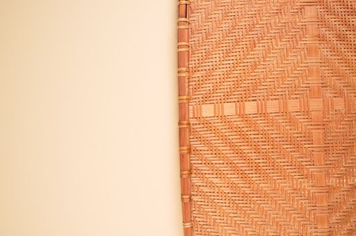 A high angle shot of a woven fabric on an orange surface