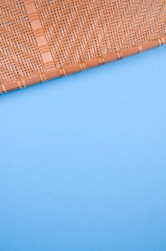 A vertical high angle shot of a woven fabric on a blue surface