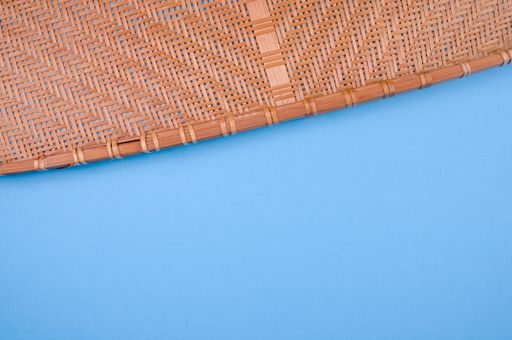 A high angle shot of a woven fabric on a blue surface