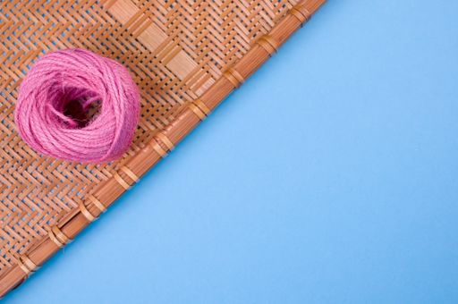 A high angle shot of a delicious donut on a woven fabric on a blue surface