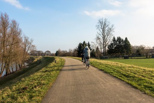The people cycling on the long pathway in the River Park Maasvallei in Limburg, Netherlands