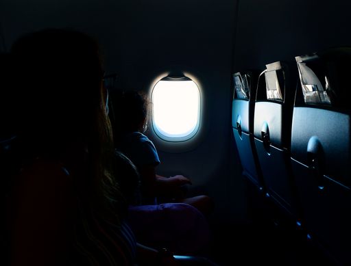 A closeup shot of the plane window captured from a dark plane