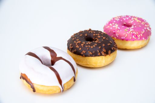 A closeup of delicious glazed doughnuts isolated on a white background