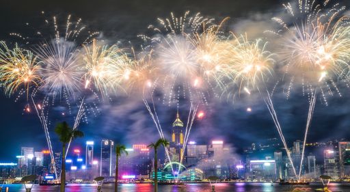 A beautiful wide shot of breathtaking fireworks in the night sky during holidays over the city