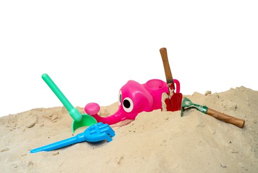 A closeup shot of beach toys on the sand isolated on a white background