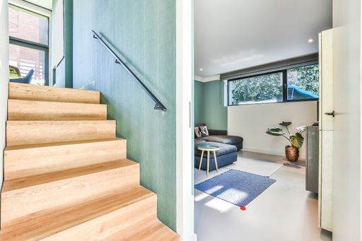 A modern apartment interior with a staircase leading to the second floor