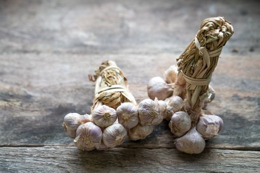 A bundle of garlic bulbs on a wooden surface