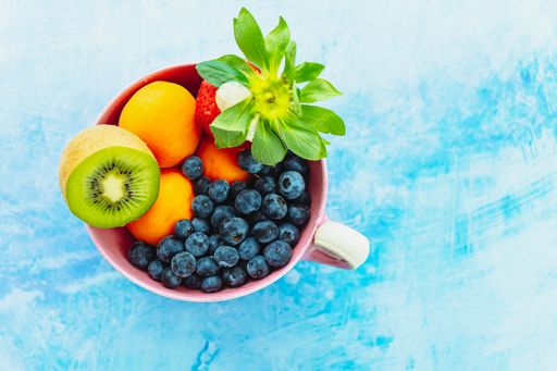 A top view of fresh fruits and berries in a bowl
