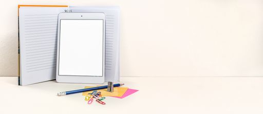 A panoramic view of a tablet, notepad, and pencil on white background
