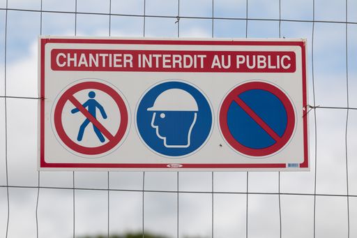 A closeup shot of a forbidding sign hanging on the mesh accessing only employees entry