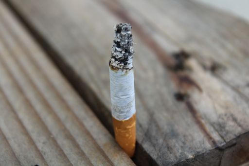 A closeup shot of a cigarette butt on a wooden surface