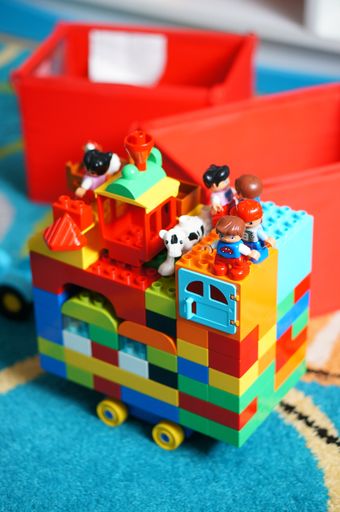 A vertical shot of a colorful block with toys made of lego bricks on a carpet in the children room