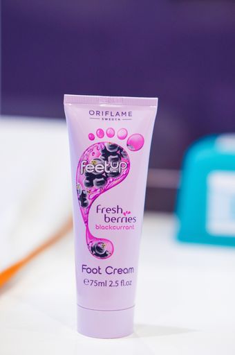 A vertical shot of an Oriflame foot cream with a smell of fresh blackcurrant berries in a small tube